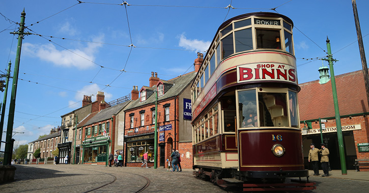 Exterior view of tram travelling through 1900s Town at Beamish Museum, County Durham